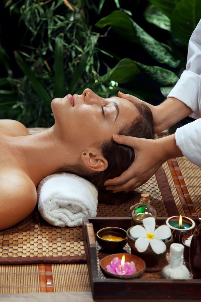A relaxing head massage surrounded by greenery and spa candles
